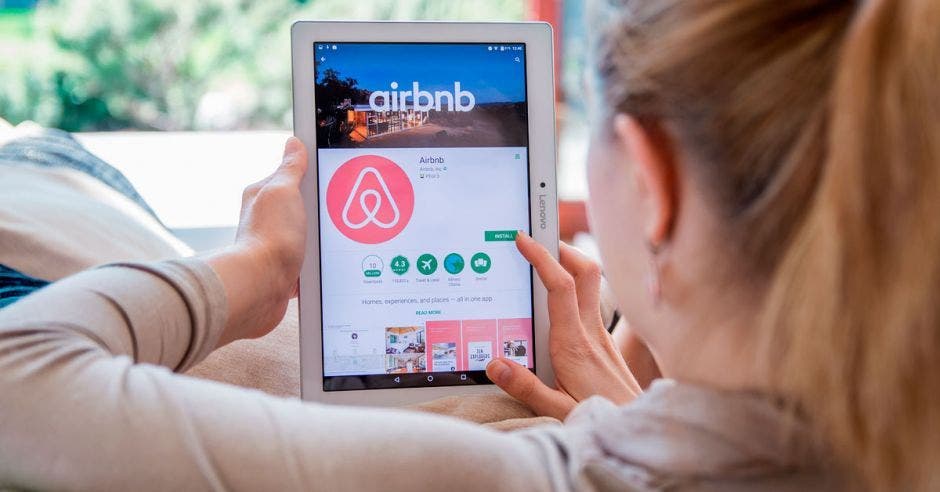 Una mujer revisa la página de Airbnb en su tablet