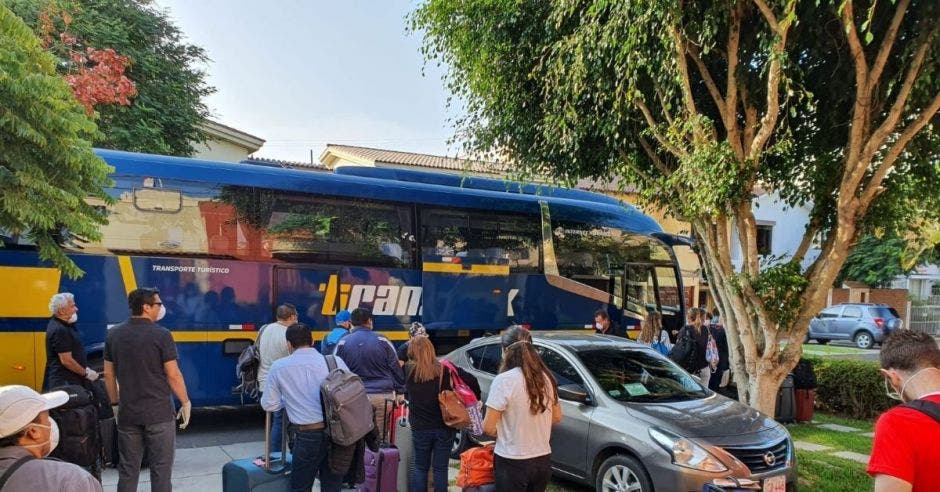 un grupo de personas espera un autobús