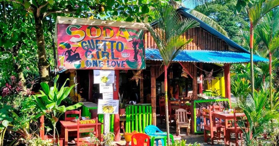 Restaurante tradicional costarricense Soda - colorida casa de madera rodeada de exuberante vegetación tropical en Puerto Viejo, Costa Rica