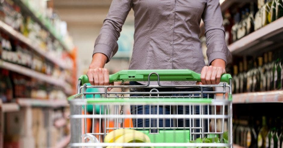 Una mujer empuja un carrito de supermercado