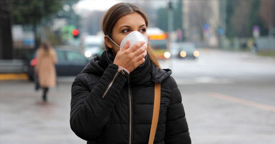 Una mujer usa mascarilla en la calle