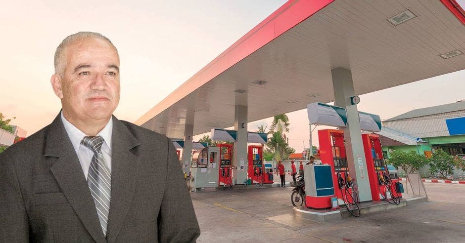 Un empresario con una gasolinera de fondo