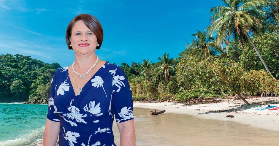 Una mujer posa junto a una playa