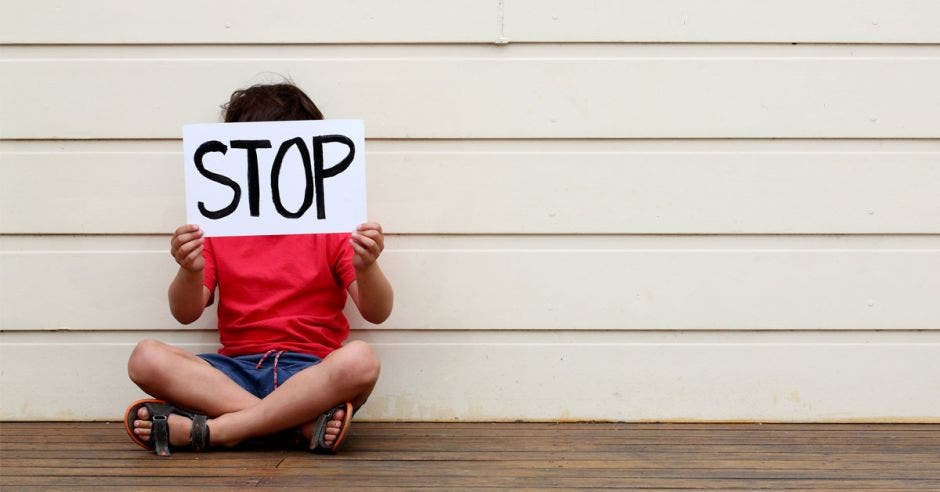 niño  con cartel de stop