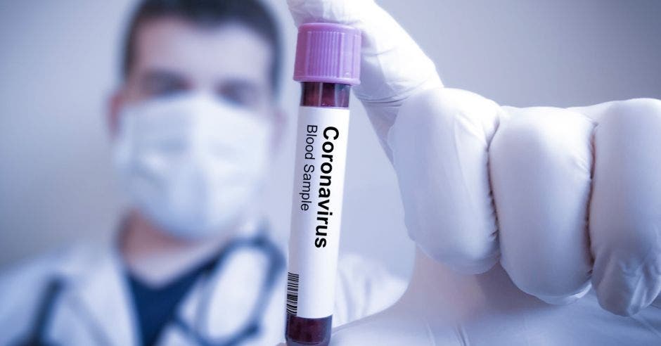 Un médico sosteniendo un tubo de ensayo de sangre con la palabra Coronavirus