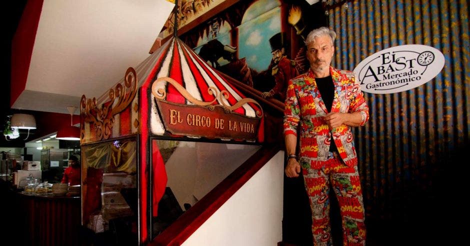 Un hombre de mediana edad posa junto a un quiosco en forma de carpa de circo