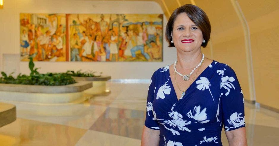 Una mujer viste un vestido azul en el lobby de un hotel