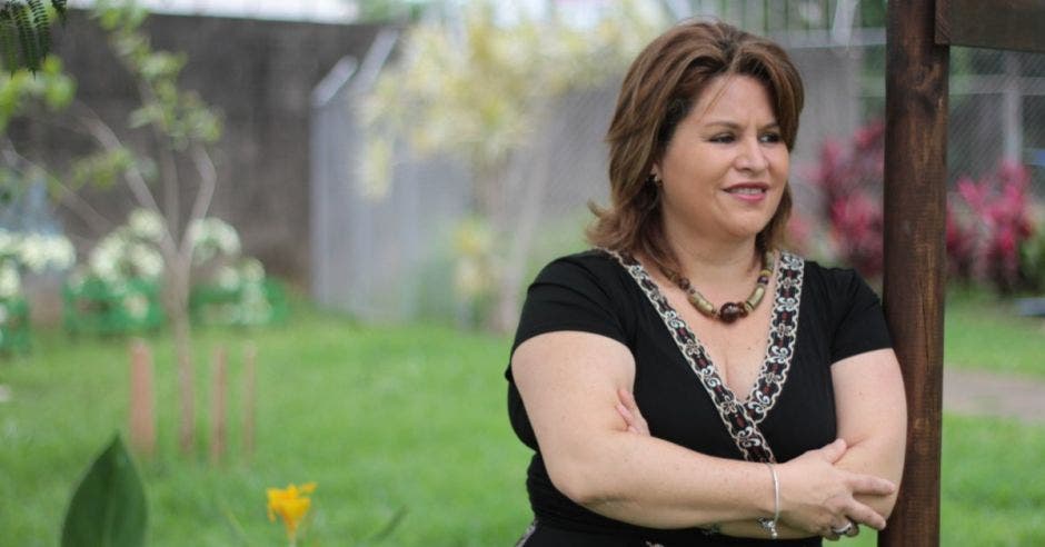 Silvia Bolaños posa en las afueras, en un jardín. Tiene el pelo corto y viste un enterizo color negro.