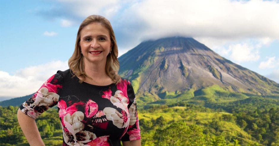 Una mujer posa sobre la figura del volcán Arenal