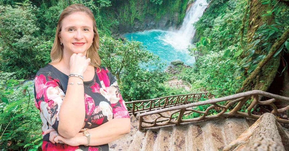 Una mujer con vestido rosa y rio celeste de fondo