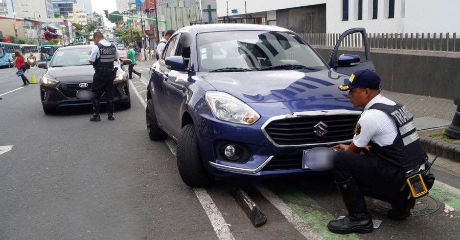 Tráfico bajando las placas a un vehículo