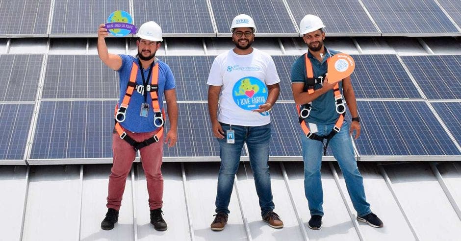 Tres colaboradores de SYKES en el área de paneles solares de uno de sus edificios