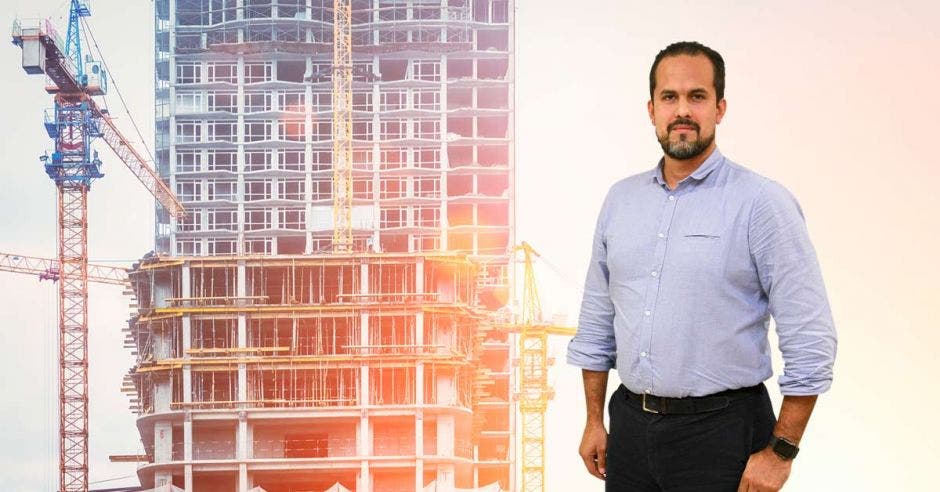 Un hombre posa junto a un edificio en construcción