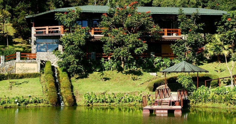 Un lago rodeado de naturaleza y cabañas de madera