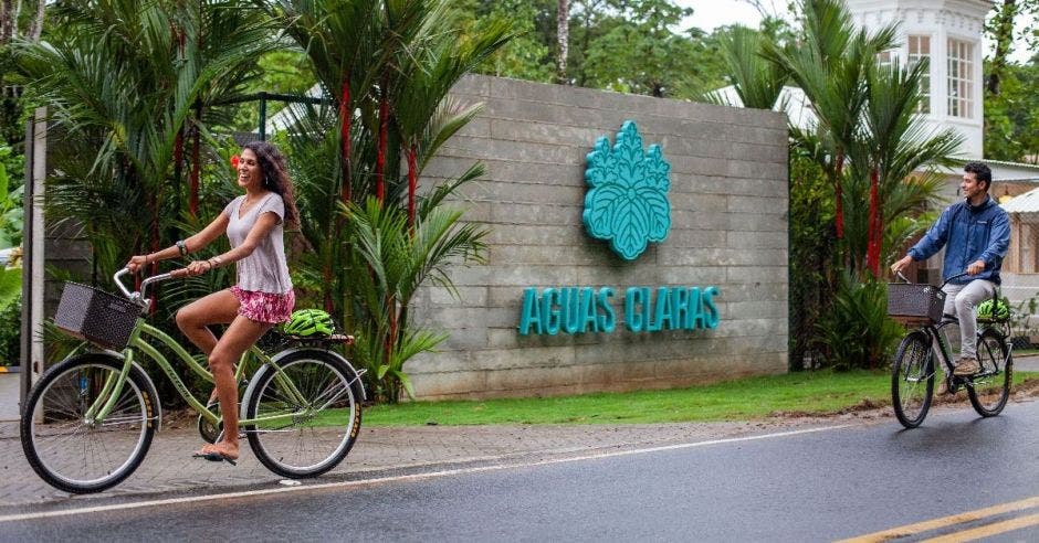 Dos personas en bicicleta pasan frente a un hotel