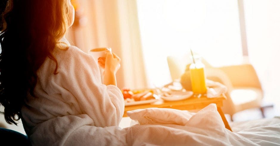 Una mujer disfruta de un desayuno en la habitación del hotel