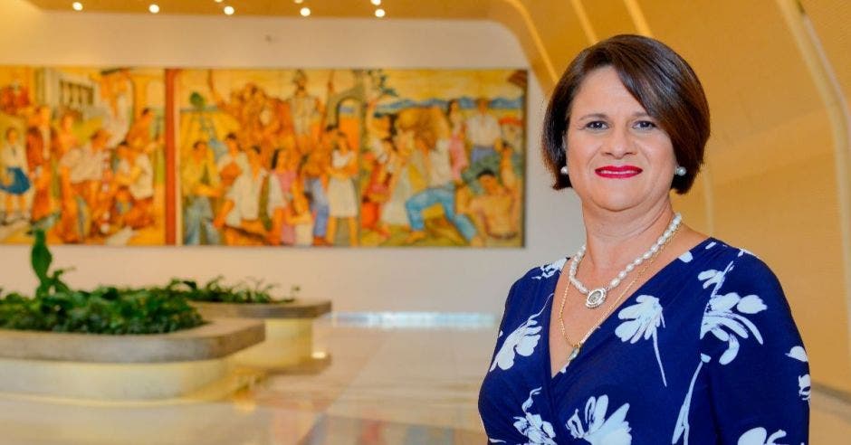 Una mujer viste un vestido azul de flores blancas