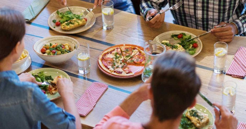 Un grupo de personas come a la mesa