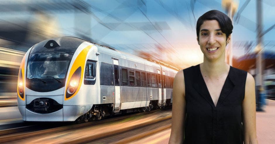 Un mujer posa frente a un tren eléctrico