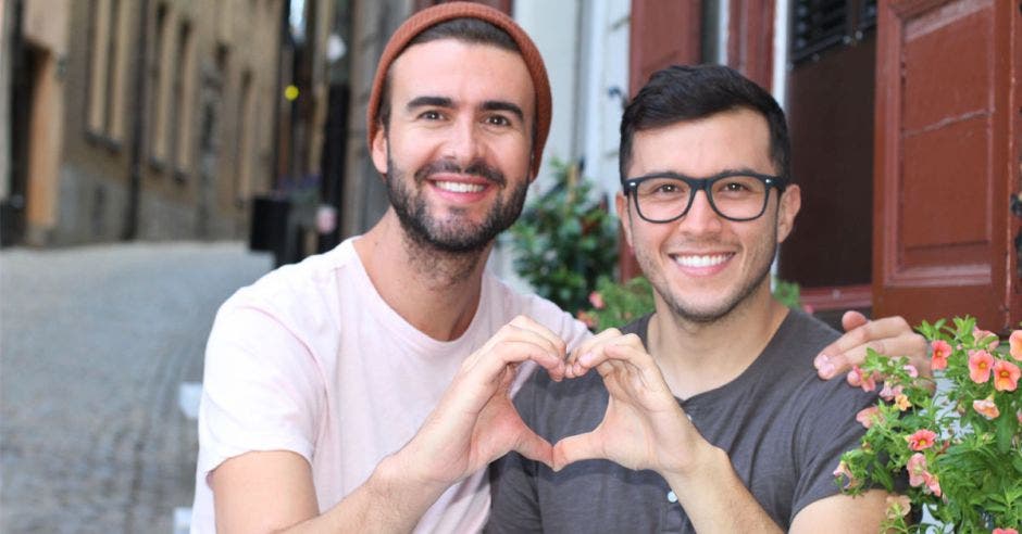 Pareja homosexual hace un corazón juntando sus manos