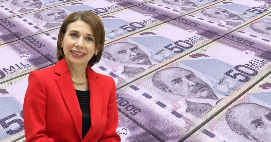 Mujer posa frente a una serie de billetes de 50 mil colones