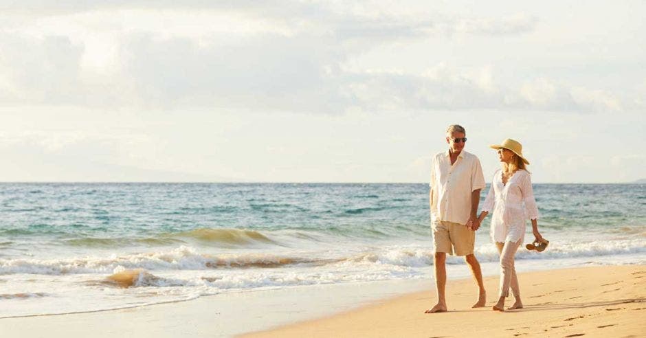 una pareja camina por la playa