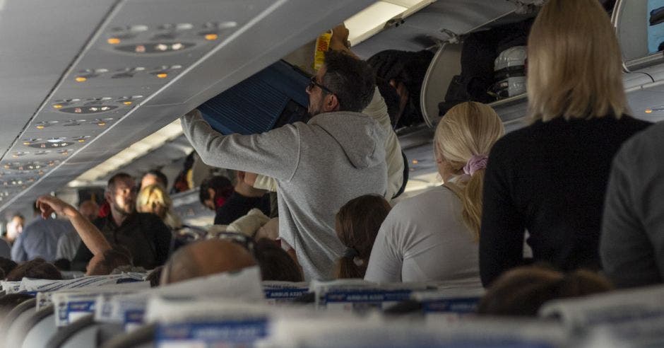 Pasajeros de avión colocan sus valijas