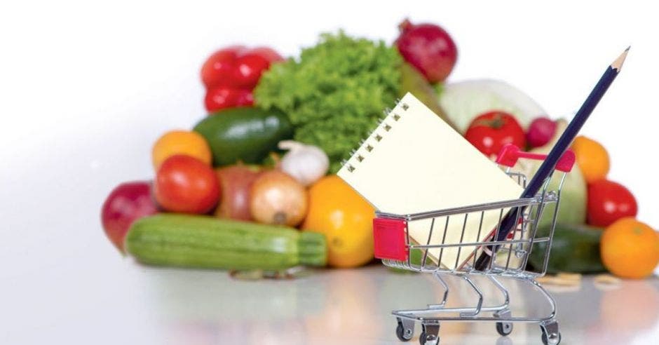 Múltiples frutas y vegetales con un carrito de supermercado y un bolígrafo