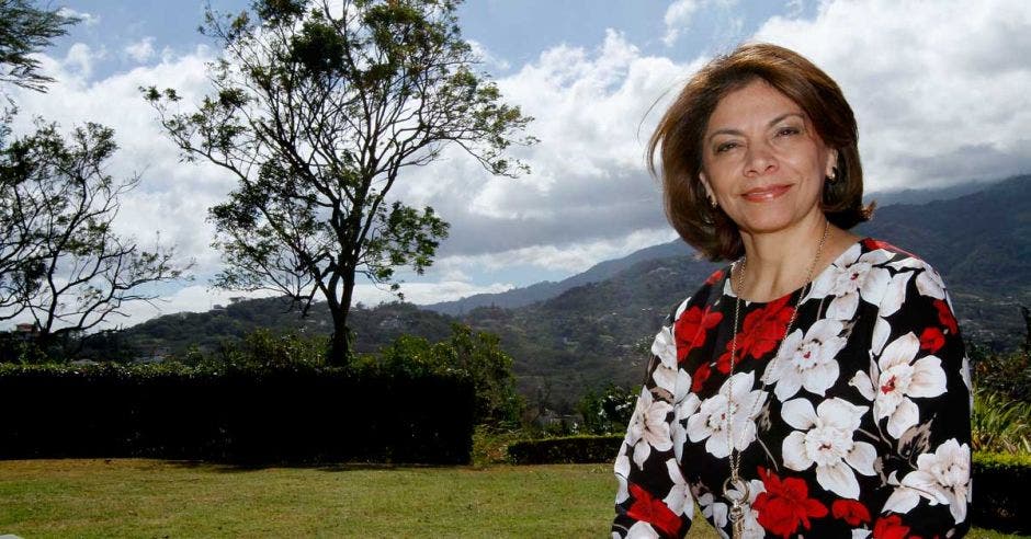 Laura Chinchilla sentada frente a un árbol