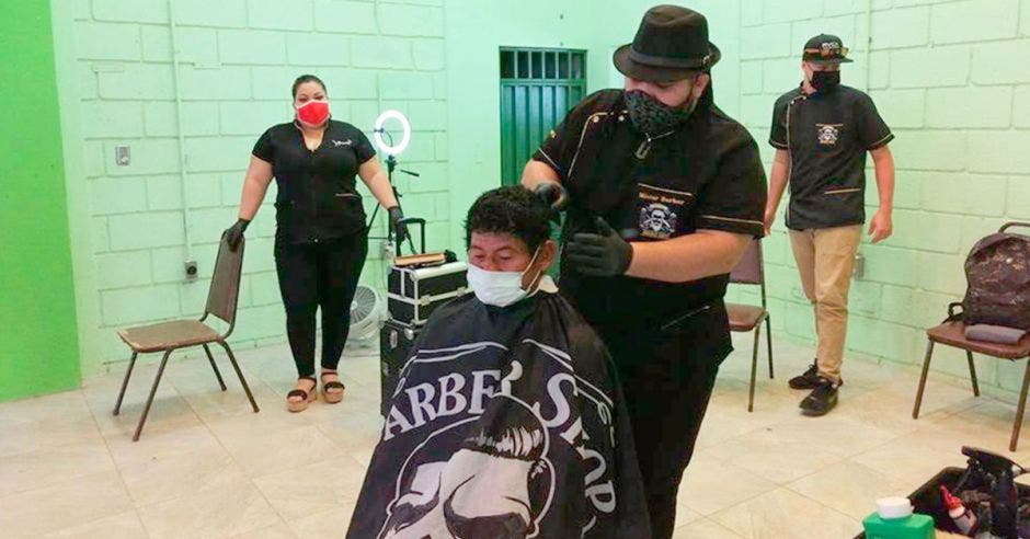 Peluqueros cortando el cabello a personas en condición de calle de Upala