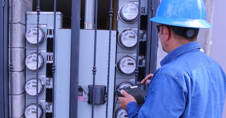 Hombre con casco revisando Medidores eléctricos