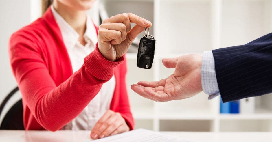 Mujer le da a un hombre llaves de un auto