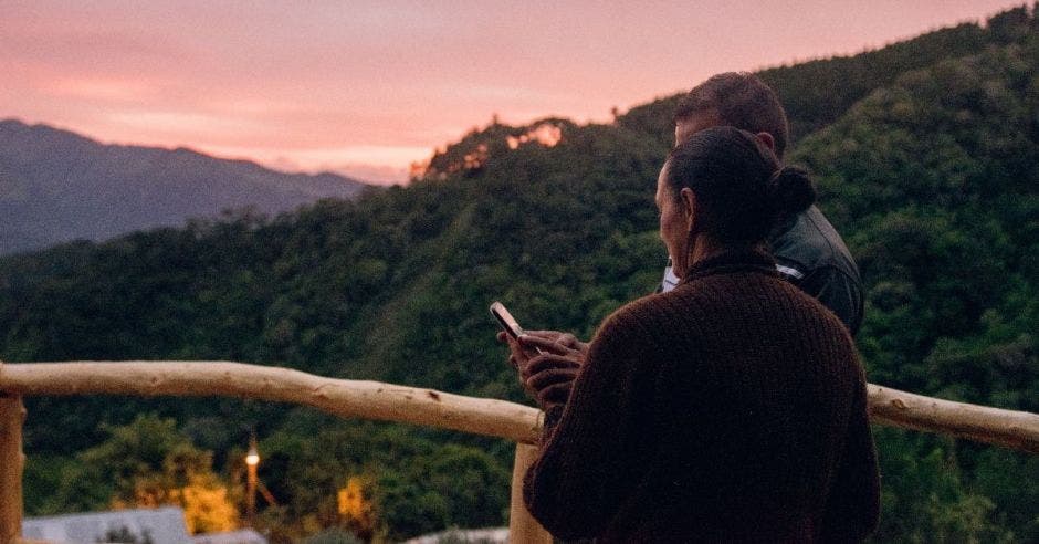 Un hombre muestra algo a una mujer en un celular