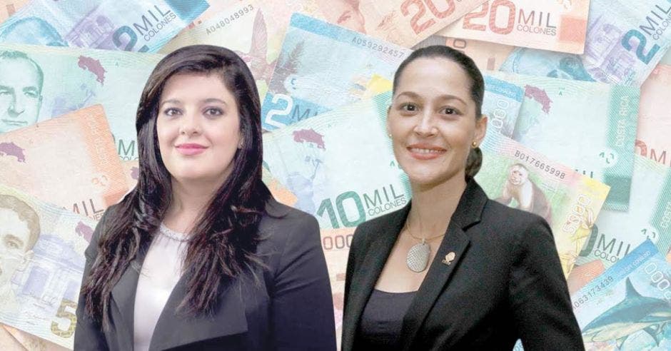 Dos mujeres posan frente a arte de billetes