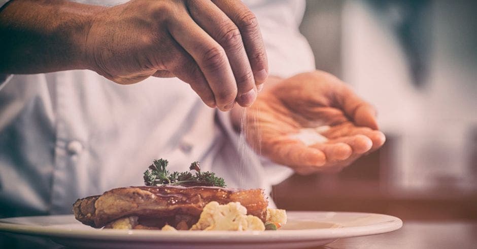 Chef condimentando carne