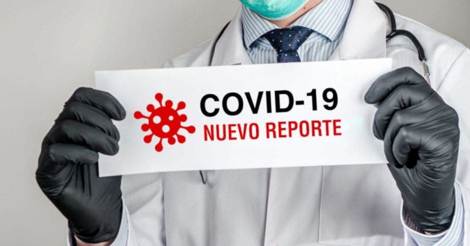 Persona sosteniendo un papel con reporte de nuevos casos de Covid-19