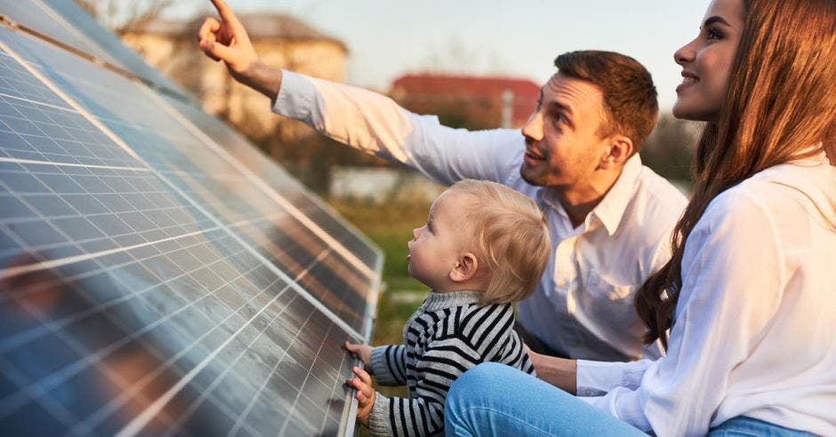 Una pareja y su hijo manipulan un panel solar