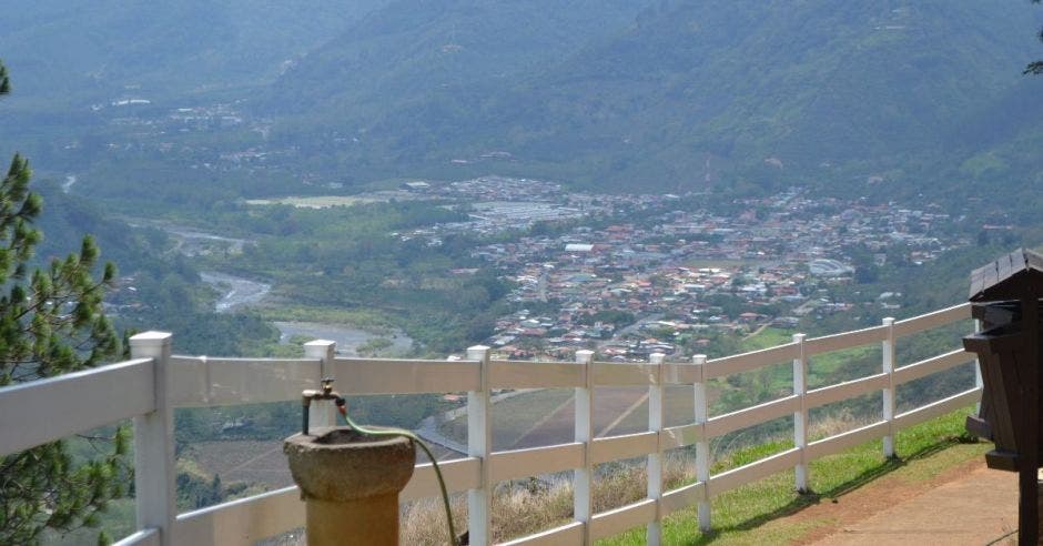 Un mirador en la parte alta de una montaña, separado por una baranda blanca