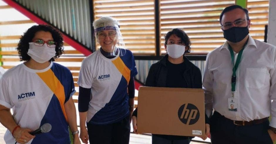 Un grupo de personas recibe equipo de computación marca HP