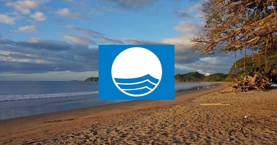 El logo de bandera azul sobre una playa al atardecer