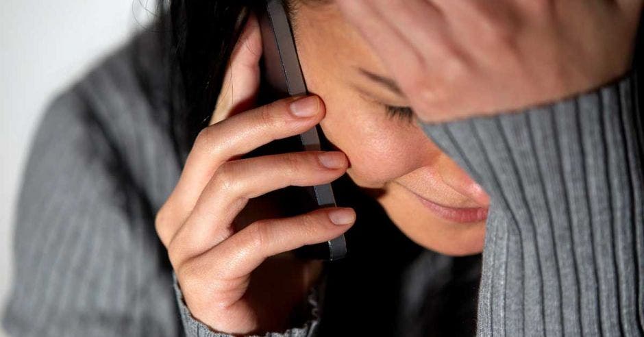 Llamada de una mujer con mano en la cara