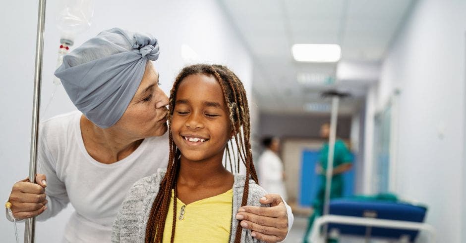 Una paciente de cáncer abraza a su nieta en un hospital.