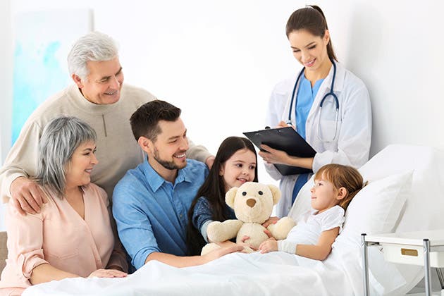 Una niña en el hospital recibe la visita de su familia.