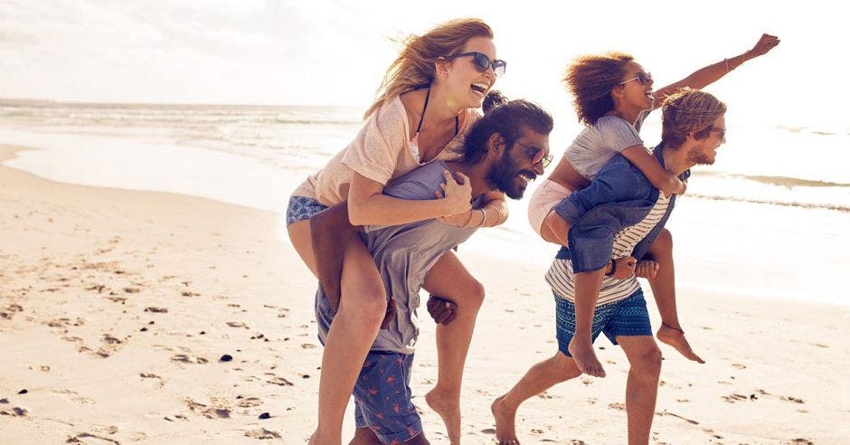 Dos parejas corren a lo largo de la playa