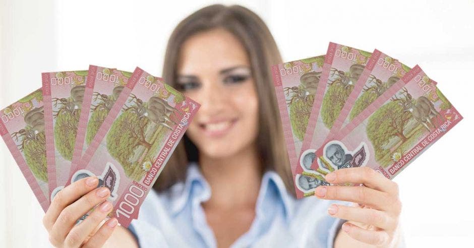 Billetes de mil colones en mano de mujer