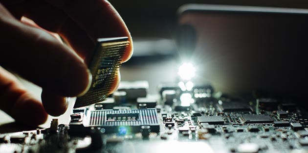 Acercamiento de una mano instalando un chip de computadora