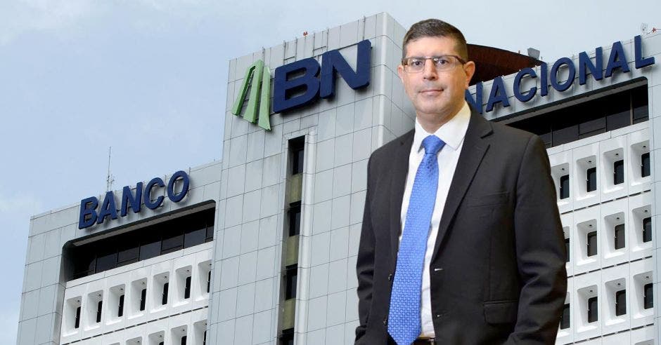 Hombre de traje frente a fachada del Banco Nacional