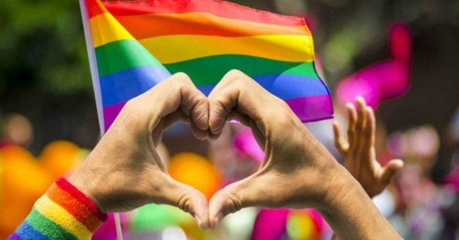 Manos en forma de corazón con bandera LGBT+