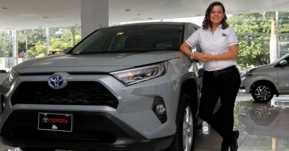 Mujer frente carro rav 4 hibrido