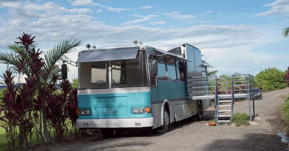 Un bus color celeste con escalera y terraza